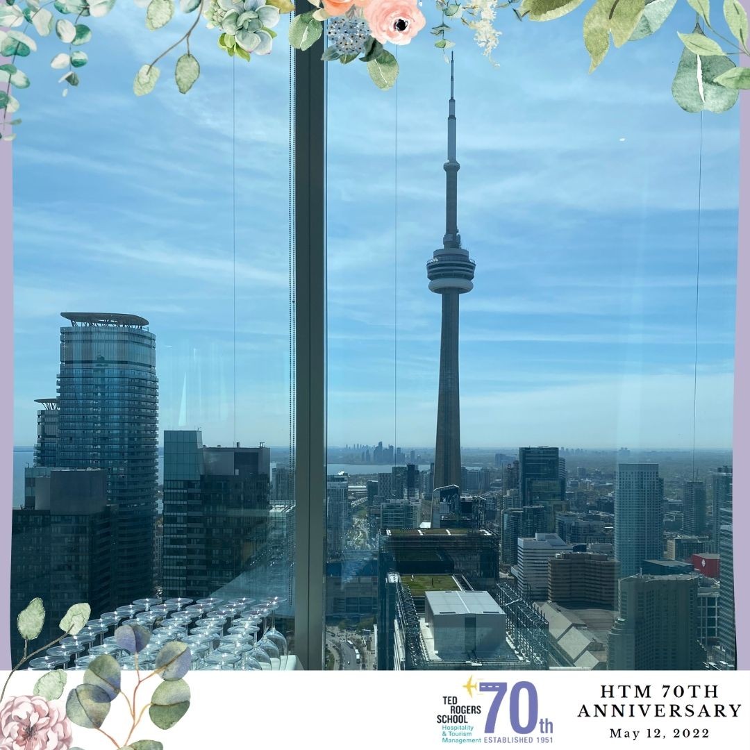 Toronto skyline from the window of HTM's 70th anniversary event. The CN Tower is surrounded by buildings.